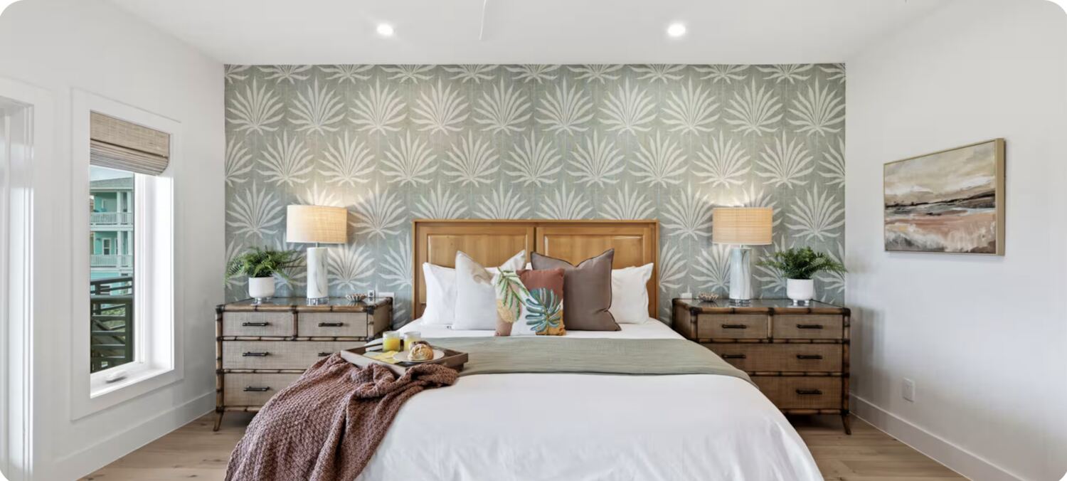 Bedroom with tropical leaf wallpaper and rattan nightstands