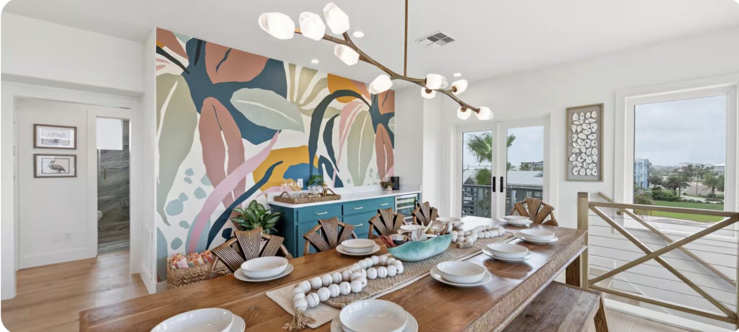 Dining room with colorful mural wall and ocean-view balcony