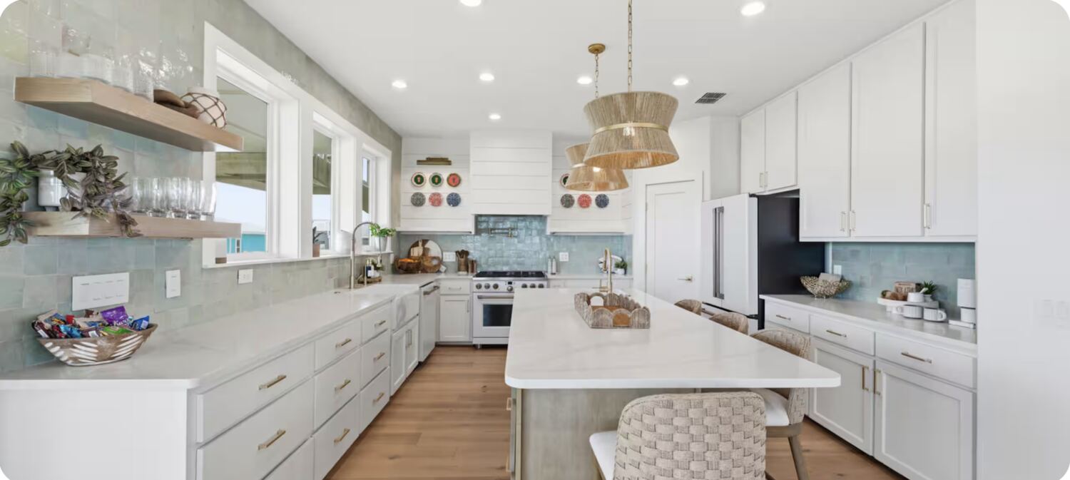 Coastal kitchen with sage tile backsplash and woven pendant lights