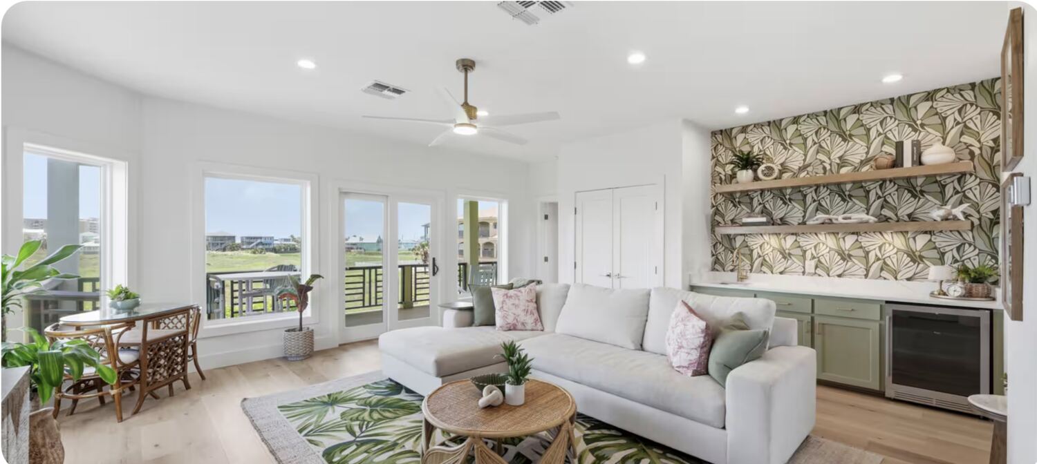 Living room with green wet bar and palm-view windows